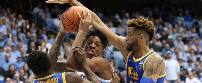 Terrell Brown and Onyebuchi Ezeakudo smother North Carolina center Armando Bacot.